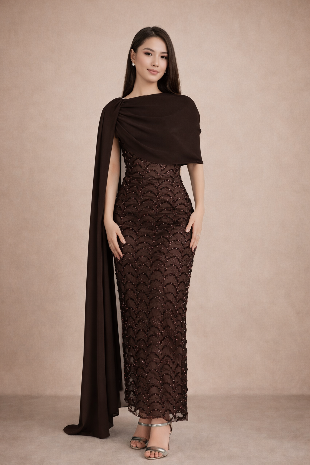 Woman wearing a dark brown lace dress with a matching shawl against a beige background